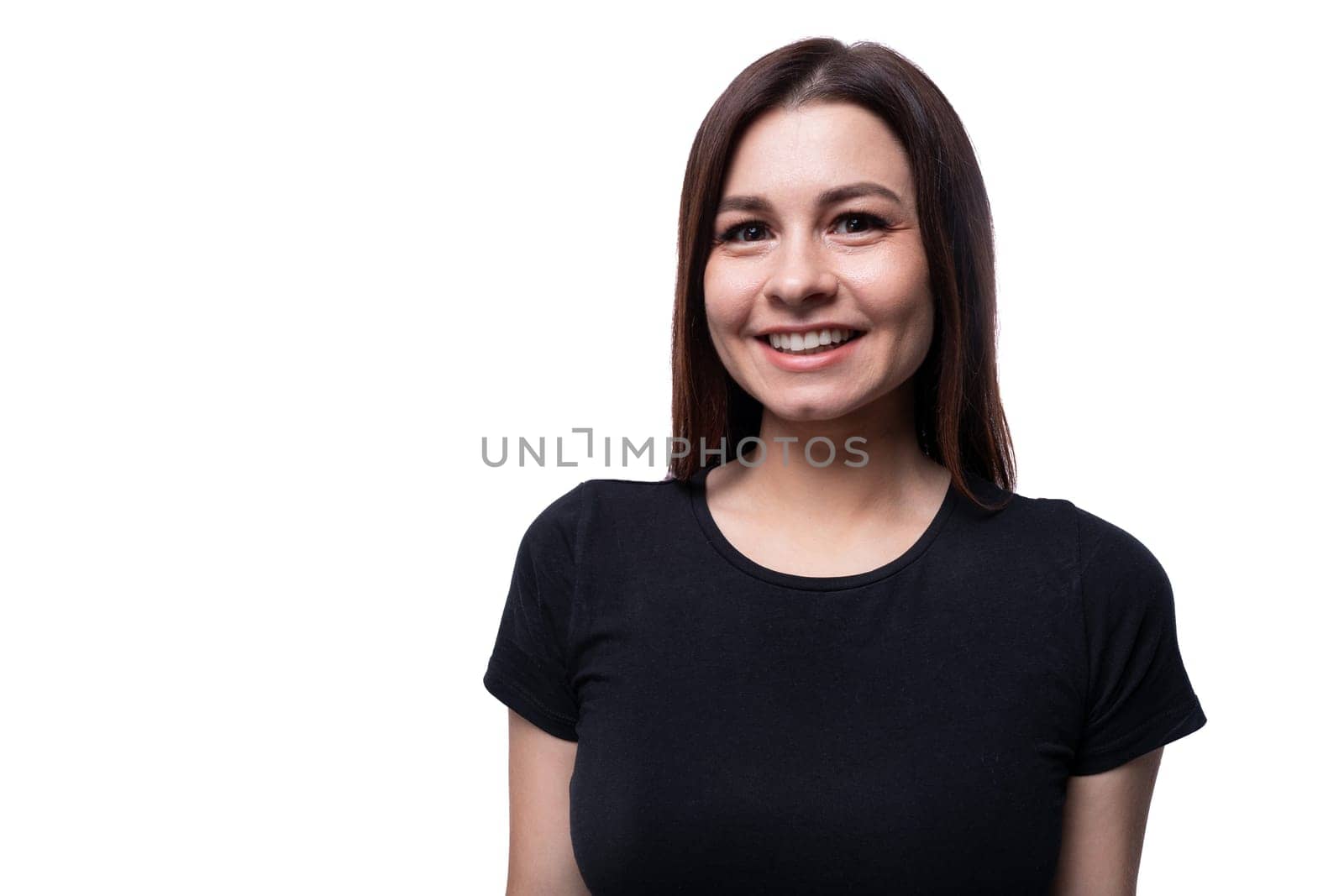 Positive pretty young brunette woman wearing a black t-shirt on a white background with copy space.