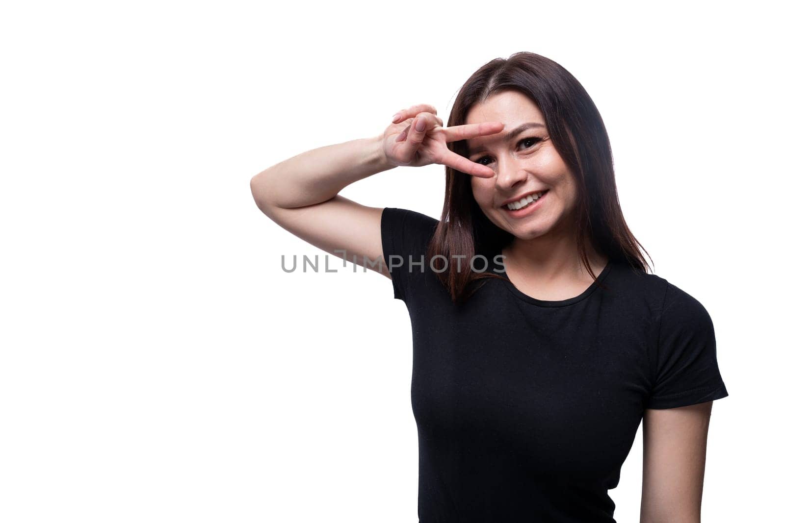 25 year old brunette woman with brown eyes greets and smiles against a background with copy space.