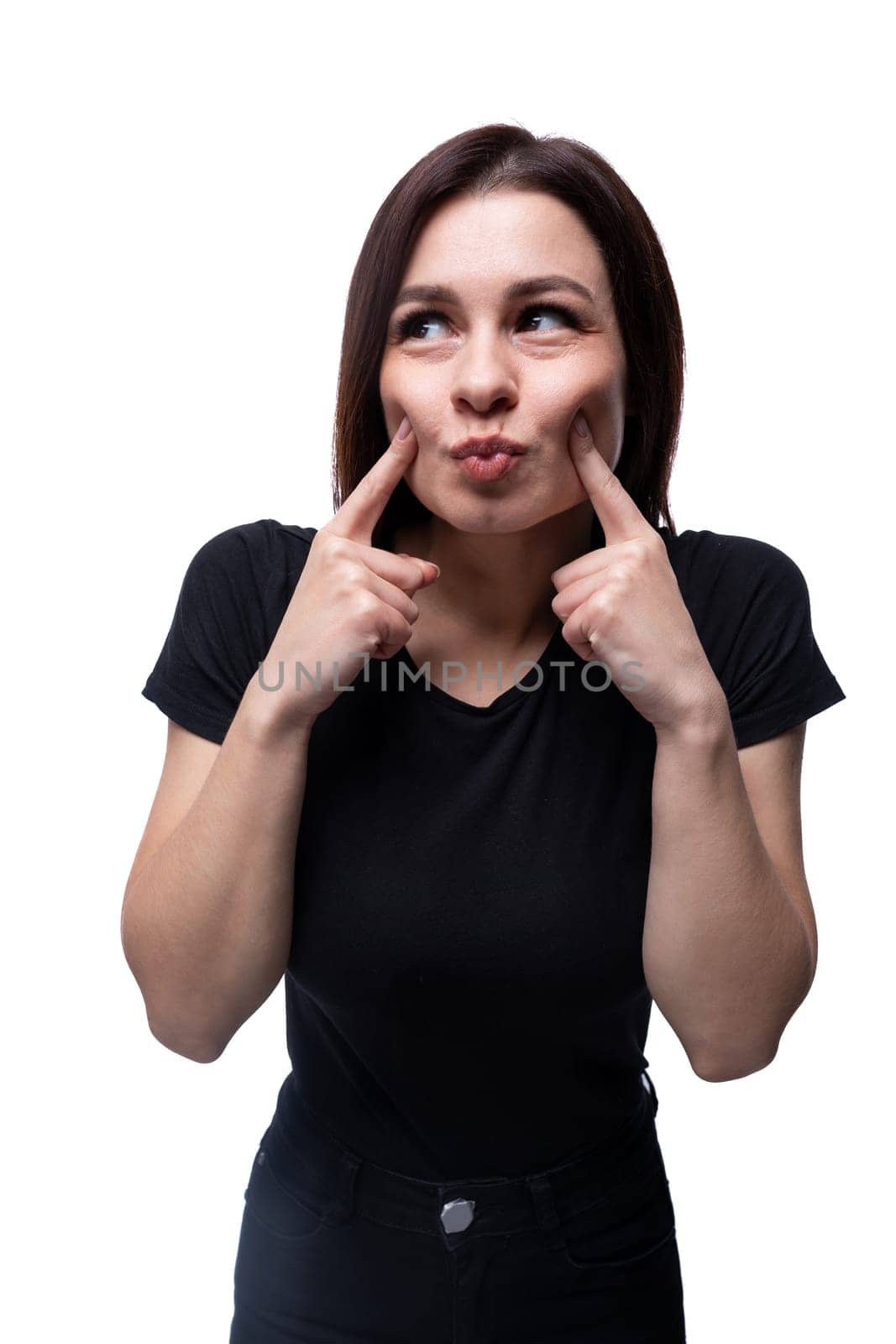 Young smiling European woman dressed in a basic T-shirt grimaces.