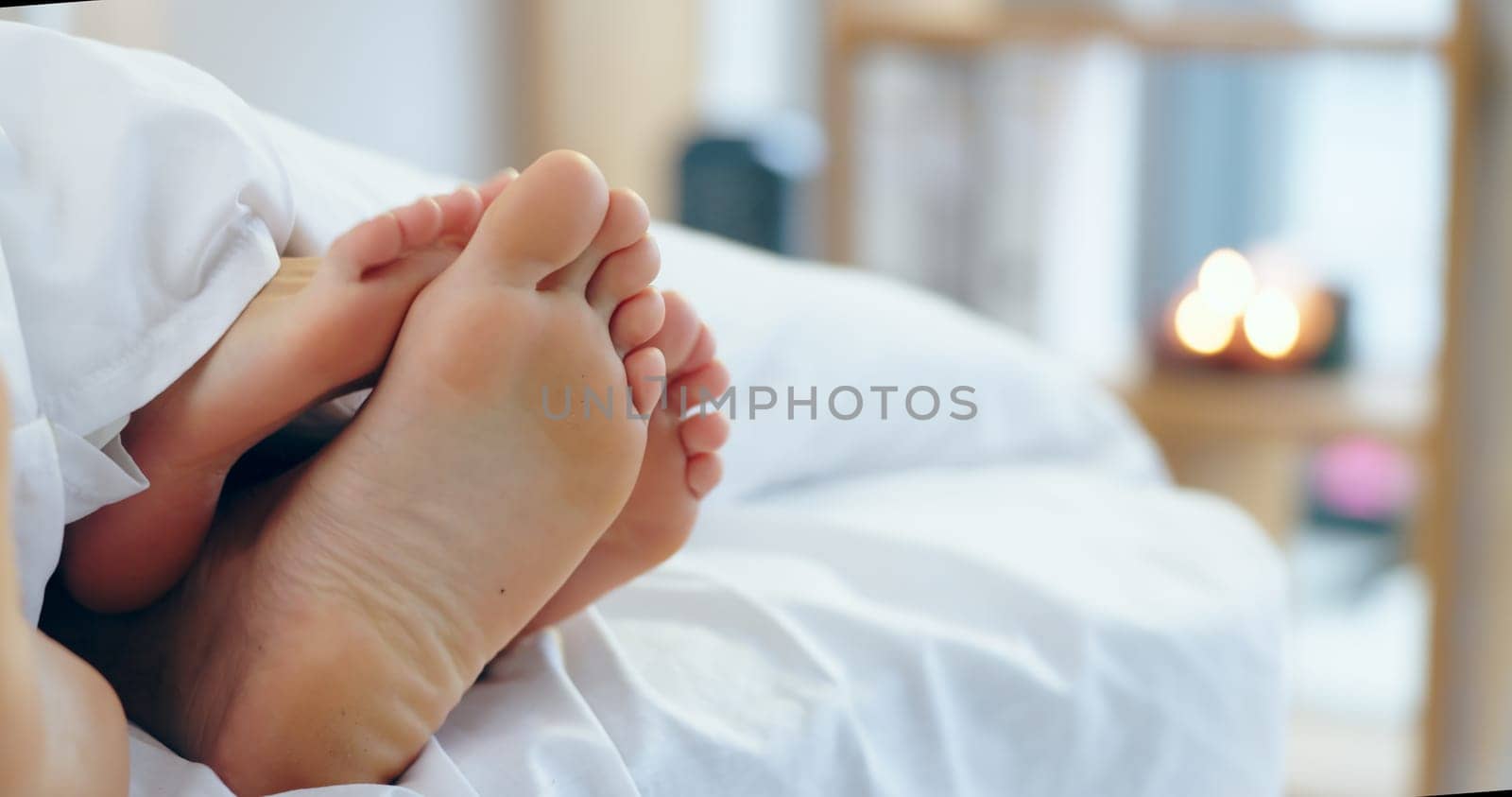 Feet, love and a couple sleeping in bed together for romance or bonding in their home in the morning. Relax, dating or playful with a man and woman barefoot in the bedroom of their apartment closeup.