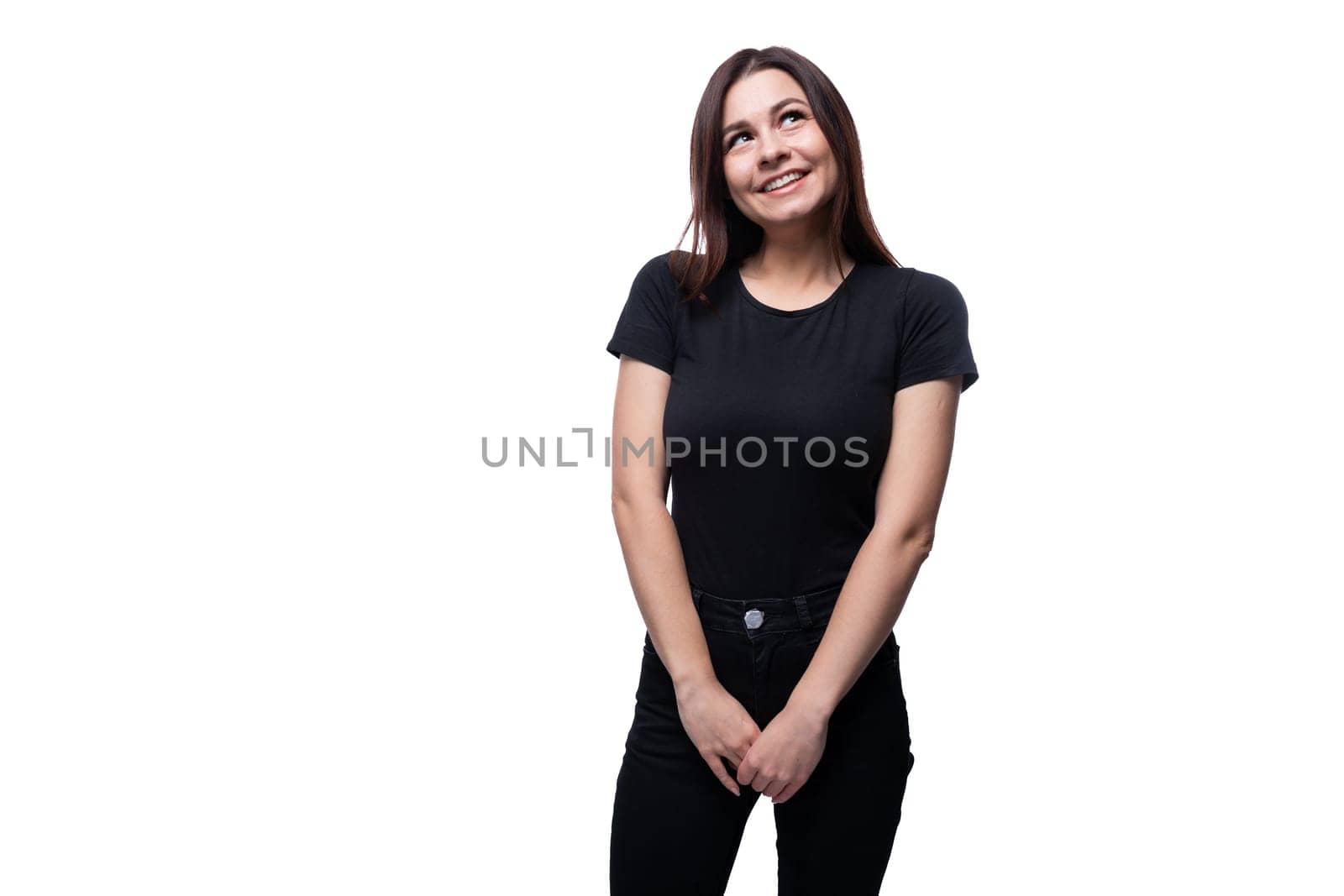 Young European woman dressed in a black T-shirt smiling on a white background with copy space by TRMK