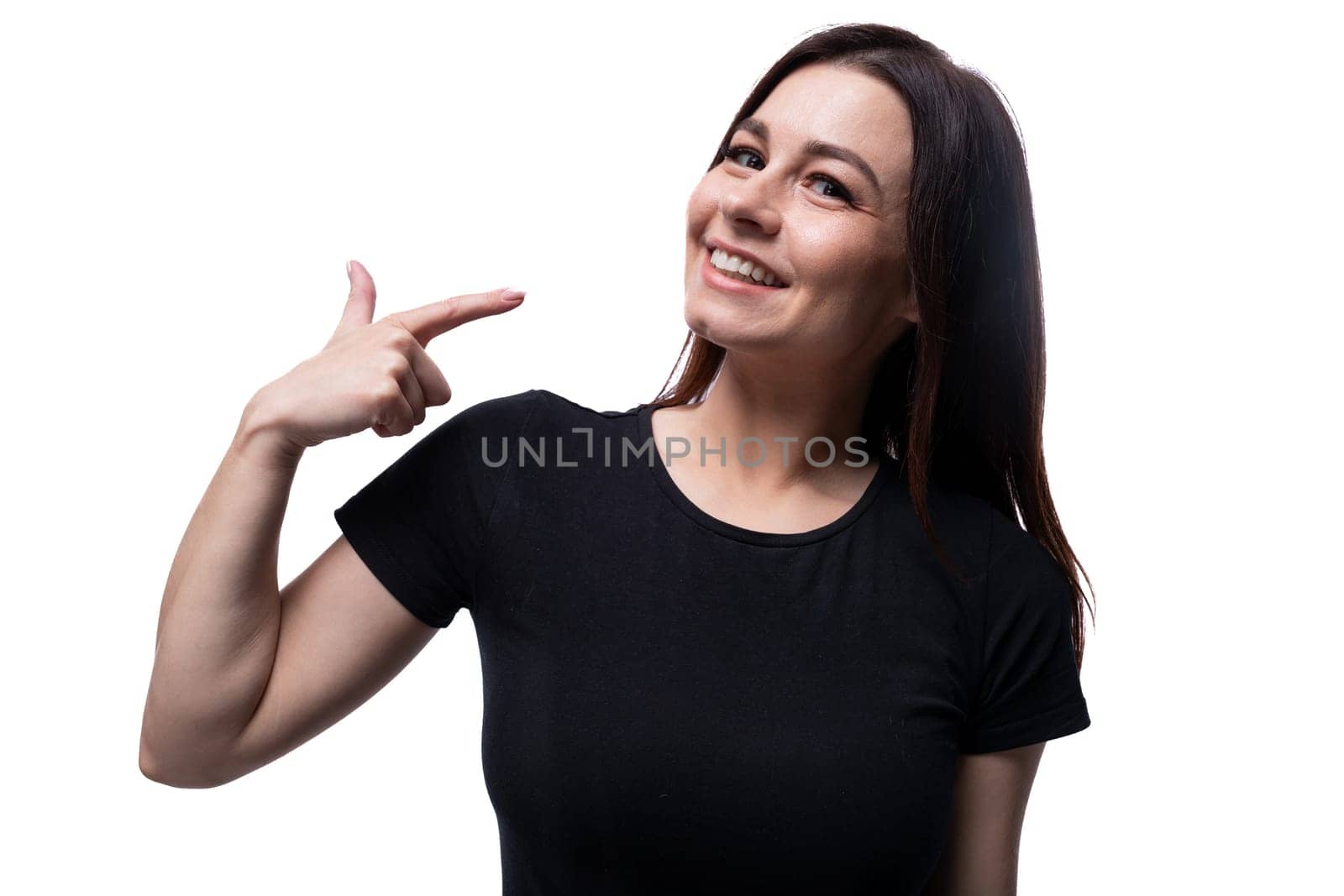 Young smiling european woman dressed in basic t-shirt pointing with finger.