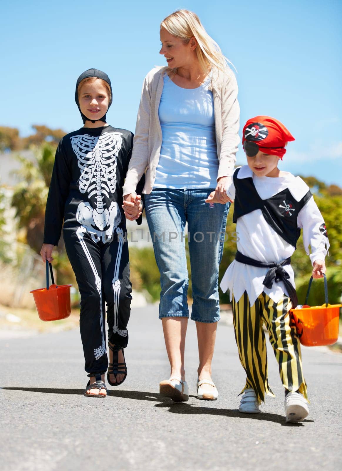 Going trick or treating. Children in costume going treat or treating with their mom. by YuriArcurs
