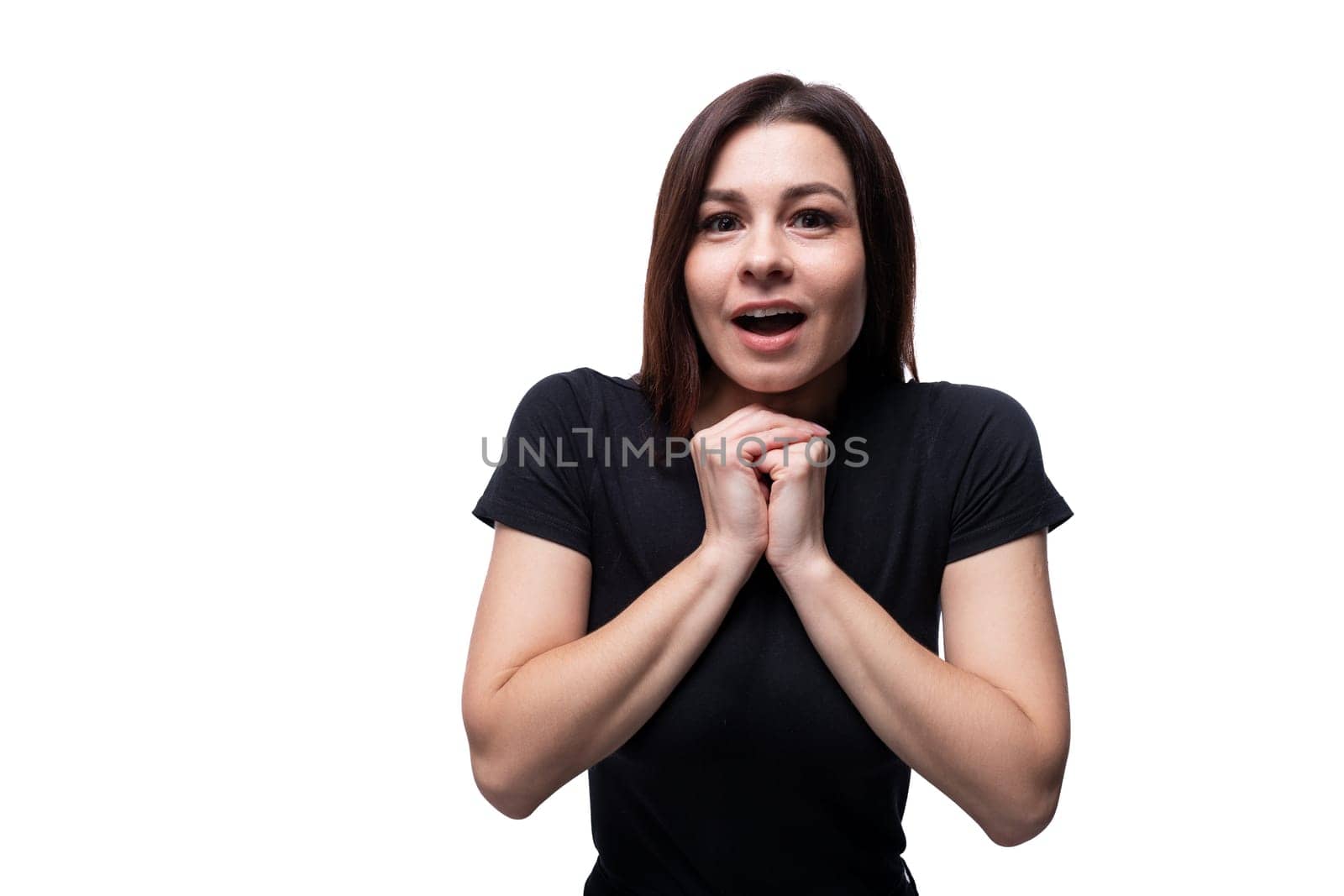 Young surprised woman with brown eyes dressed in a black T-shirt on a background with copy space.