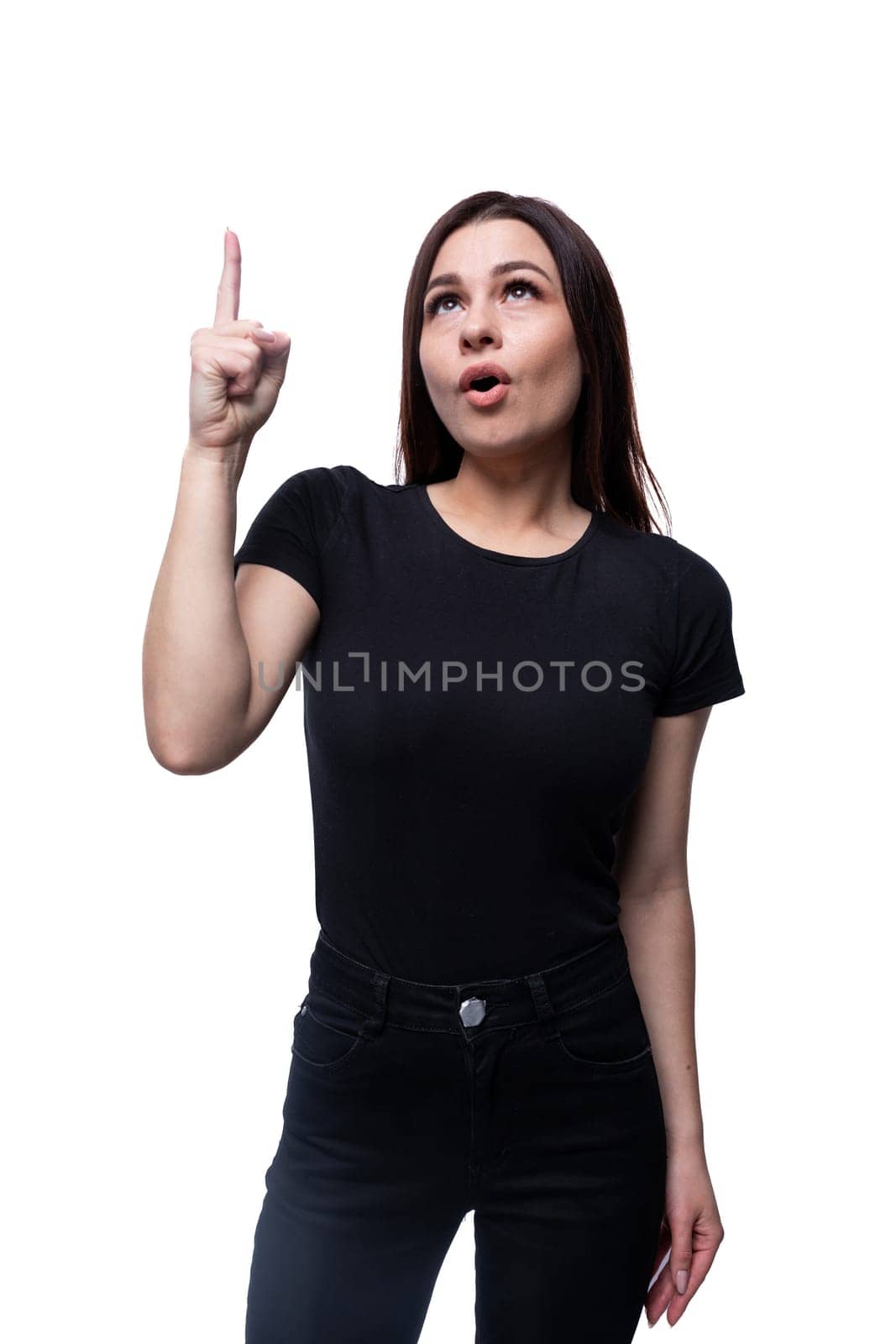 Young confident woman with black hair wearing a black T-shirt on a white background with copy space by TRMK