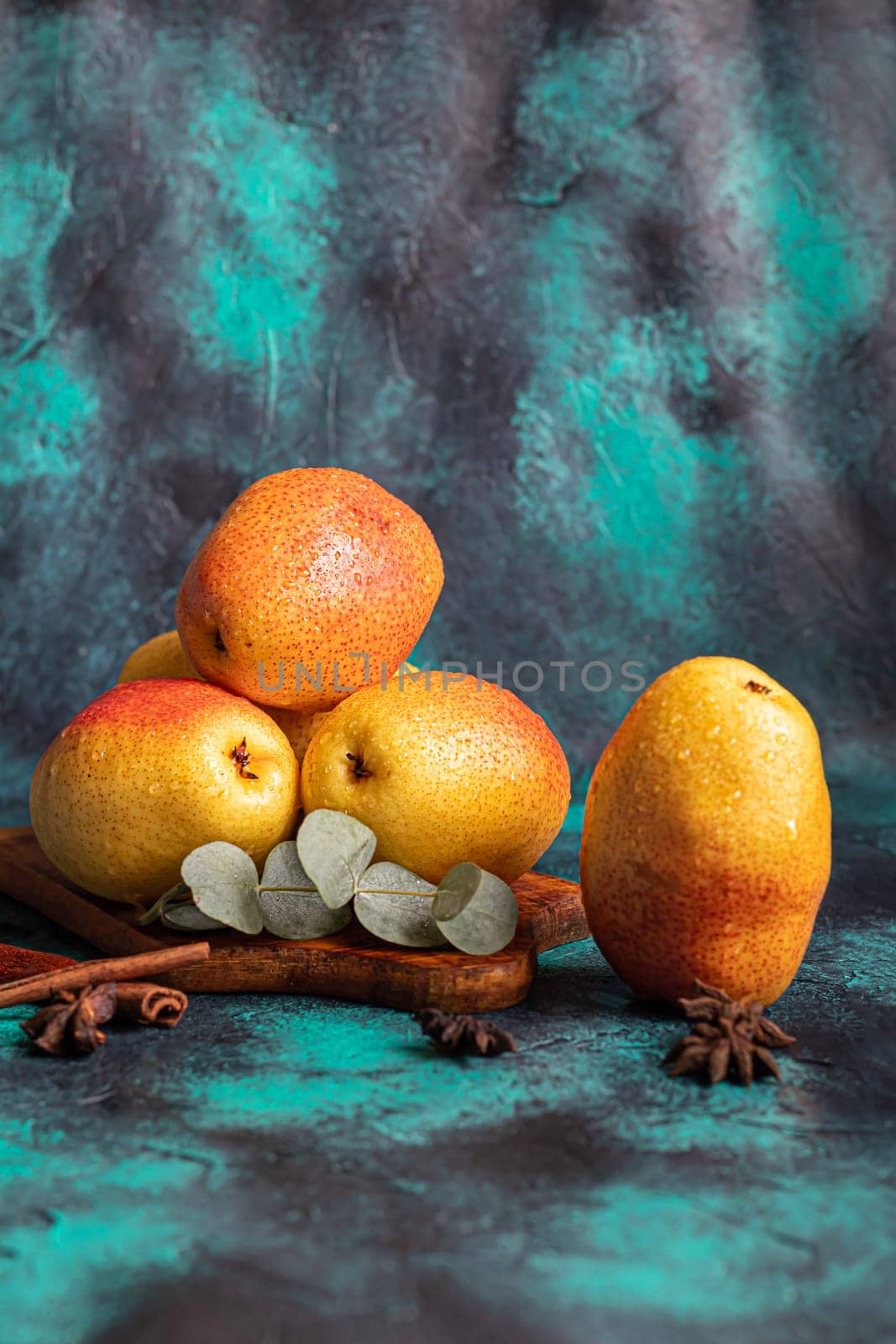 Pears on a dark background. Fresh, ripe fruits on a blue plate and in a box. Healthy eating. Copy space.