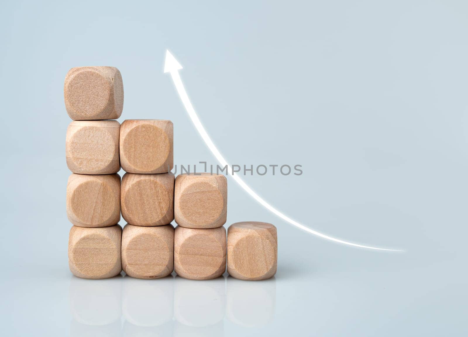 Stock trading. Finance. Investing. Growing business. Wooden blocks arranged with arrows pointing upwards and a white background.