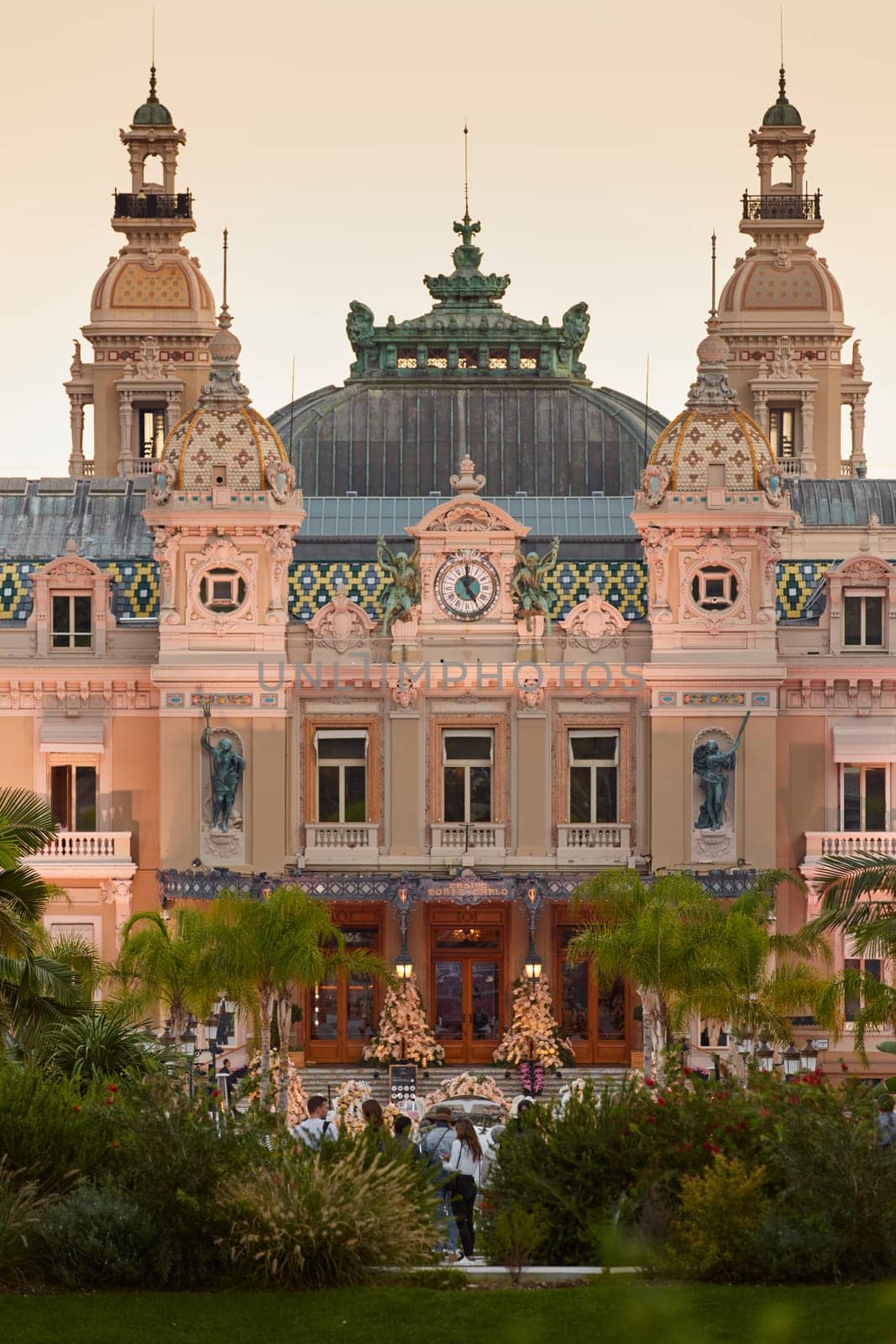 Monaco, Monte-Carlo, 12 November 2022: The famous square of Casino Monte-Carlo is at dusk, attraction night illumination, luxury cars, players, tourists, splashes of fountain. High quality photo