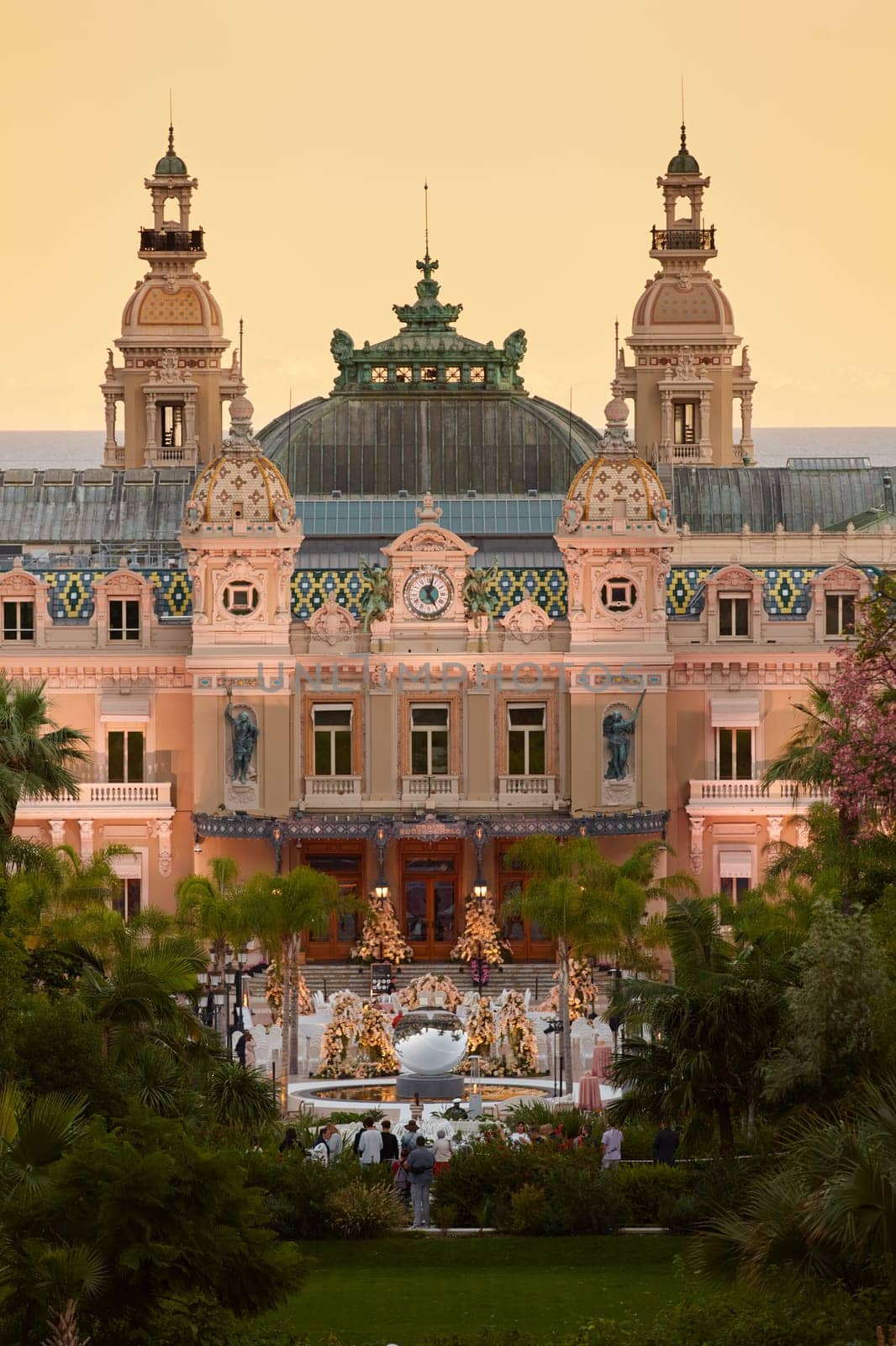 Monaco, Monte-Carlo, 12 November 2022: The famous square of Casino Monte-Carlo is at dusk, attraction night illumination, luxury cars, players, tourists, splashes of fountain. High quality photo