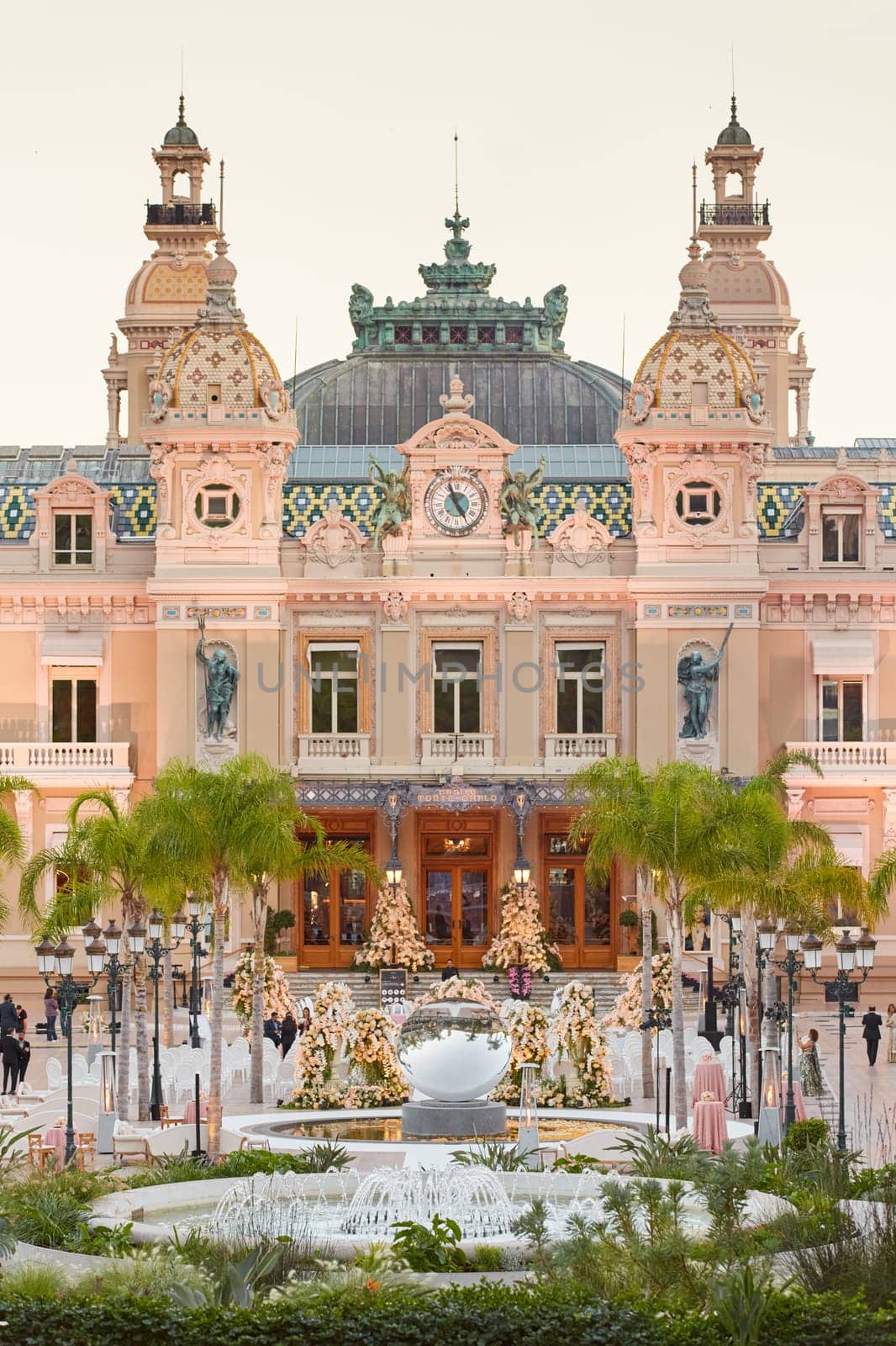 Monaco, Monte-Carlo, 12 November 2022: The famous square of Casino Monte-Carlo is at dusk, attraction night illumination, luxury cars, players, tourists, splashes of fountain. High quality photo