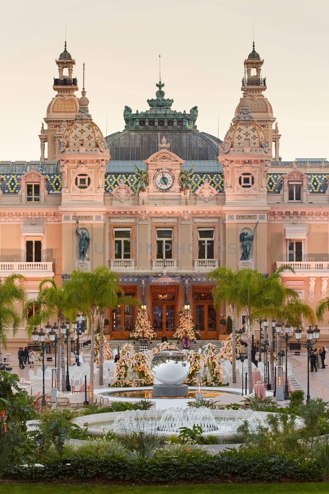 Monaco, Monte-Carlo, 12 November 2022: The famous square of Casino Monte-Carlo is at dusk, attraction night illumination, luxury cars, players, tourists, splashes of fountain. High quality photo