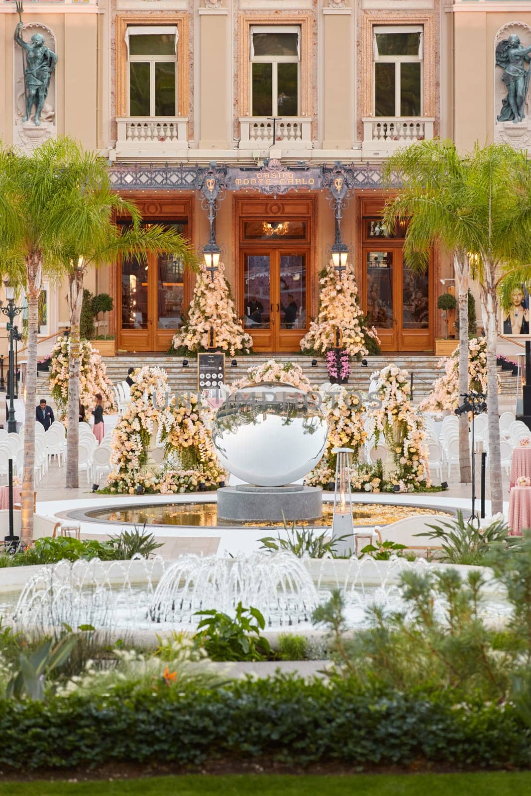 Monaco, Monte-Carlo, 12 November 2022: The famous square of Casino Monte-Carlo is at dusk, attraction night illumination, luxury cars, players, tourists, splashes of fountain. High quality photo