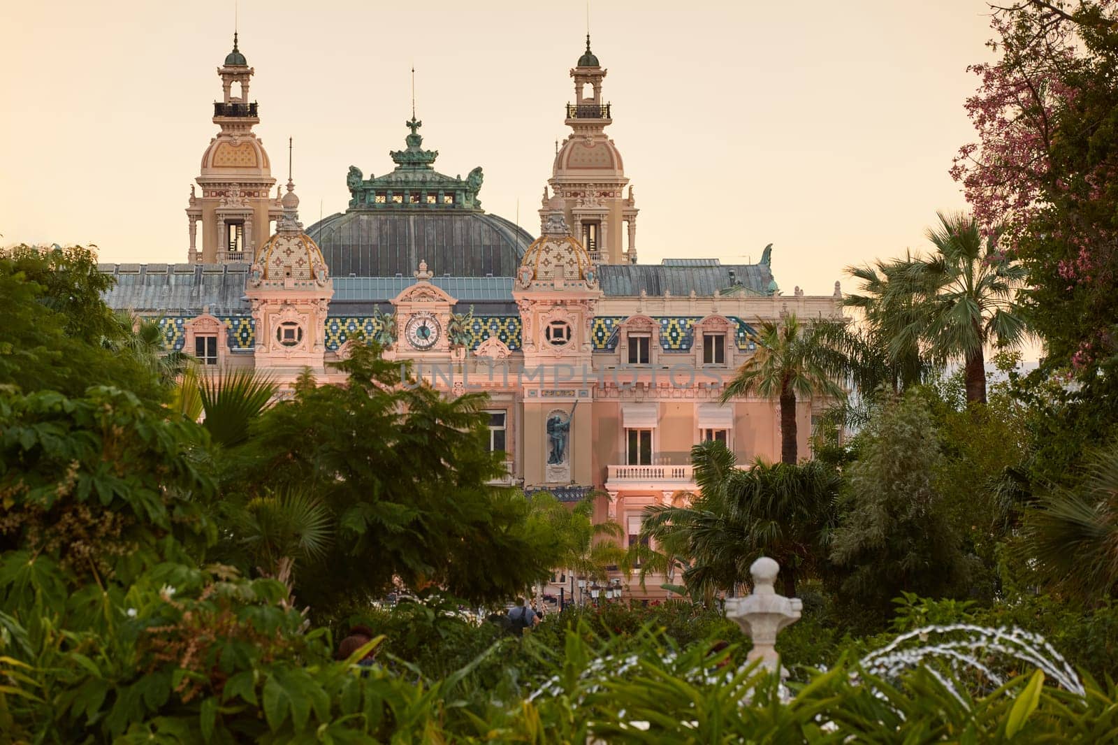Monaco, Monte-Carlo, 12 November 2022: The famous square of Casino Monte-Carlo is at dusk, attraction night illumination, luxury cars, players, tourists, splashes of fountain. High quality photo