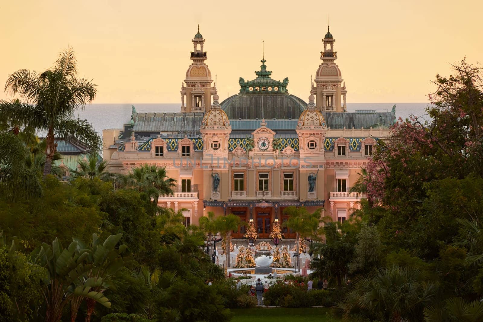 Monaco, Monte-Carlo, 12 November 2022: The famous square of Casino Monte-Carlo is at dusk, attraction night illumination, luxury cars, players, tourists, splashes of fountain. High quality photo