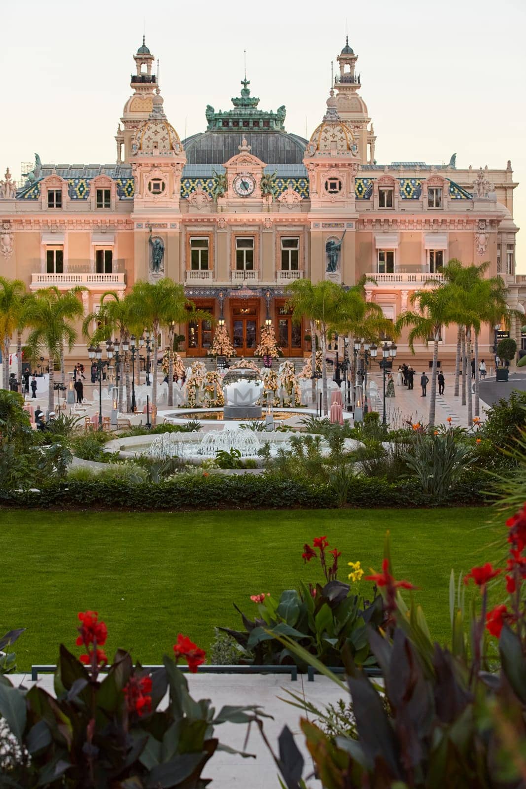 Monaco, Monte-Carlo, 12 November 2022: The famous square of Casino Monte-Carlo is at dusk, attraction night illumination, luxury cars, players, tourists, splashes of fountain. High quality photo