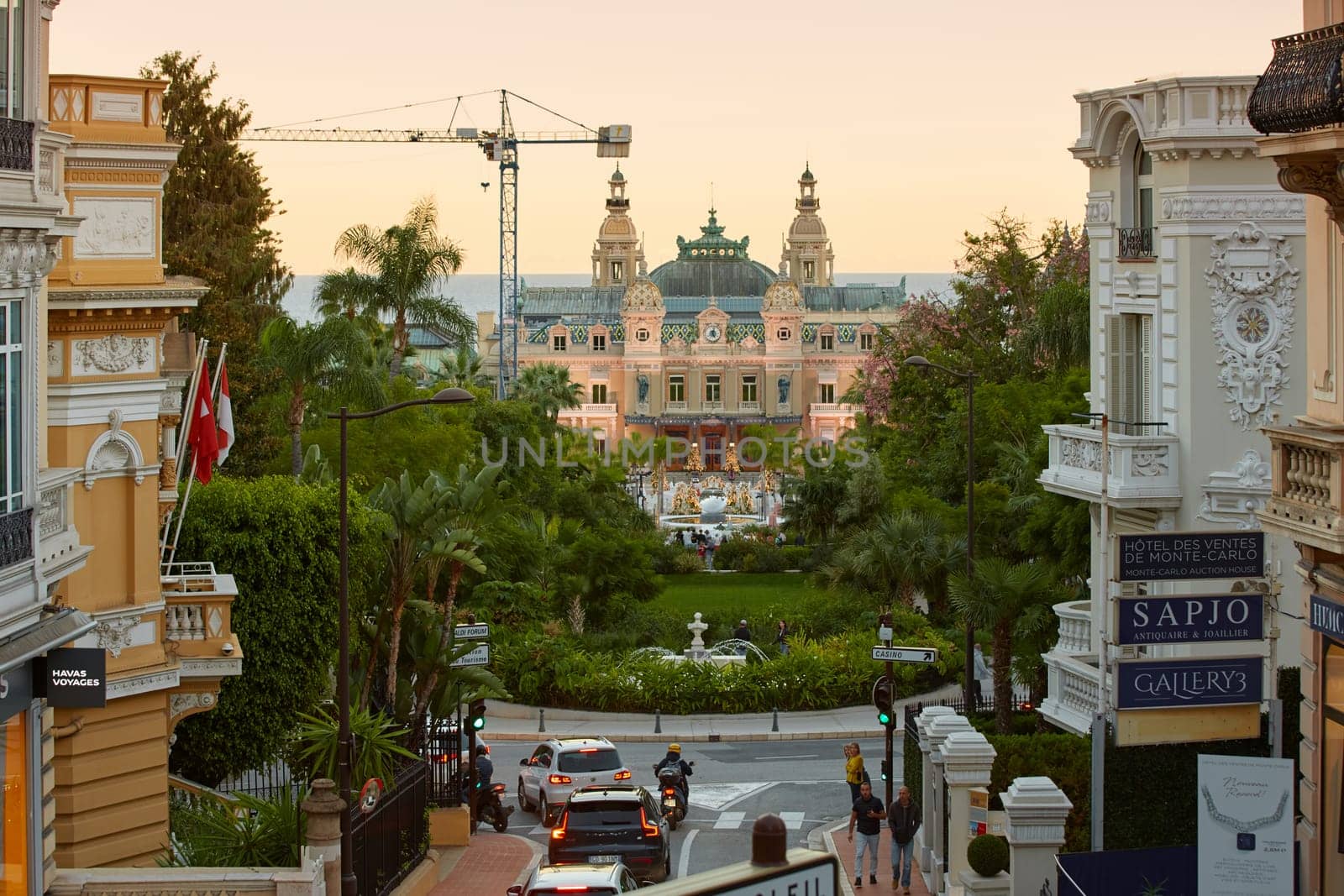Monaco, Monte-Carlo, 12 November 2022: The famous square of Casino Monte-Carlo is at dusk, attraction night illumination, luxury cars, players, tourists, splashes of fountain. High quality photo
