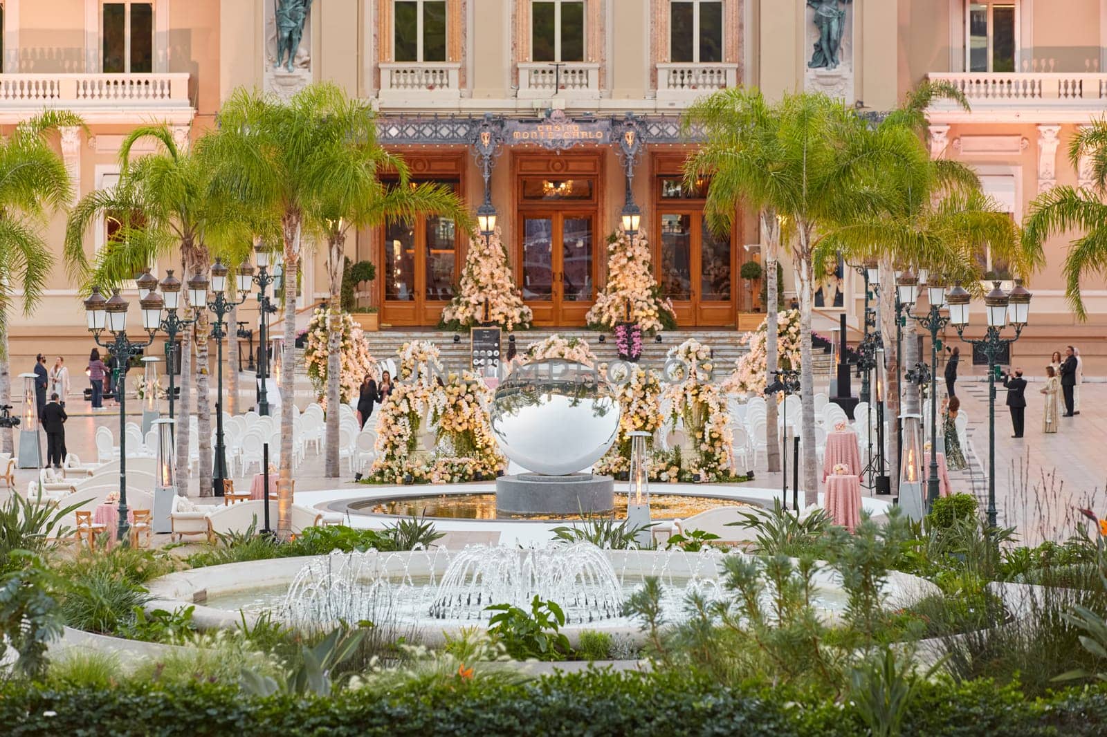Monaco, Monte-Carlo, 12 November 2022: The famous square of Casino Monte-Carlo is at dusk, attraction night illumination, luxury cars, players, tourists, splashes of fountain. High quality photo