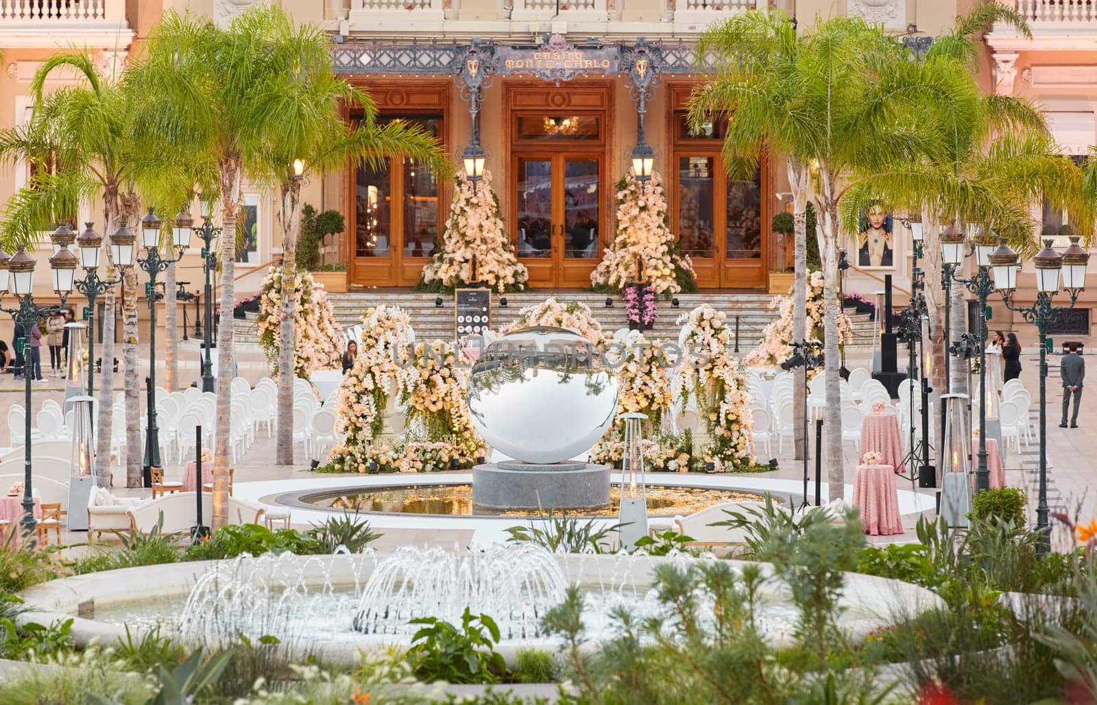 Monaco, Monte-Carlo, 12 November 2022: The famous square of Casino Monte-Carlo is at dusk, attraction night illumination, luxury cars, players, tourists, splashes of fountain. High quality photo