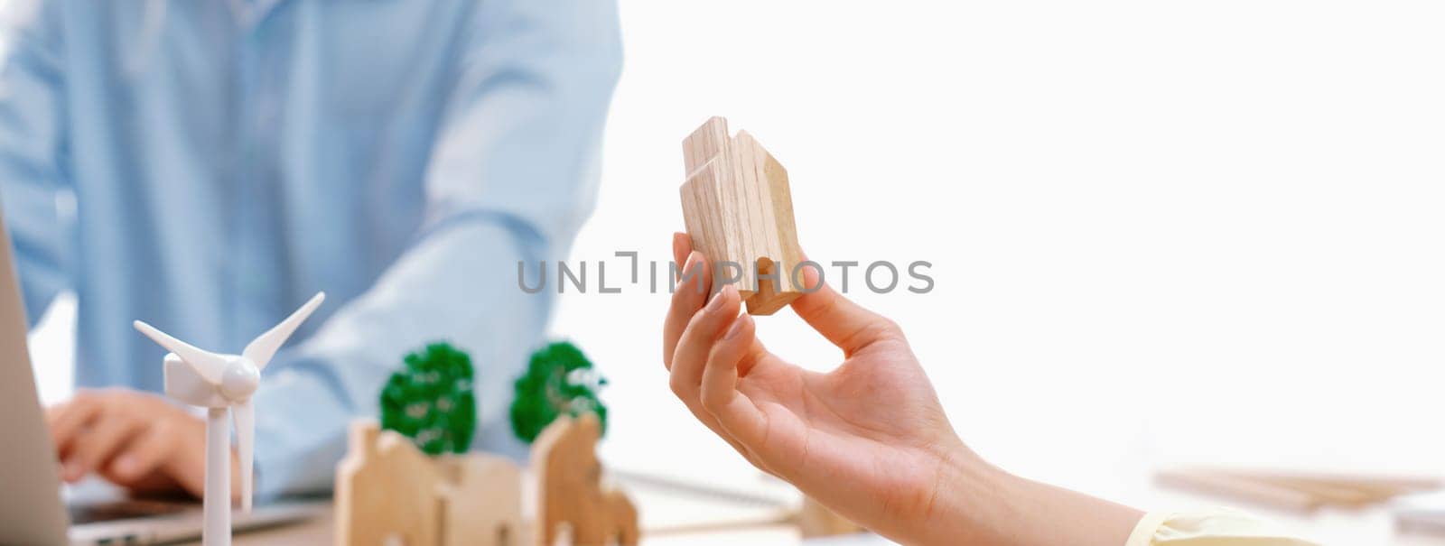 Businesswoman decides to Invest in green business. Skilled architects plan to build a eco house by using renewable energy at table with environmental document scatter around. Close up. Delineation.