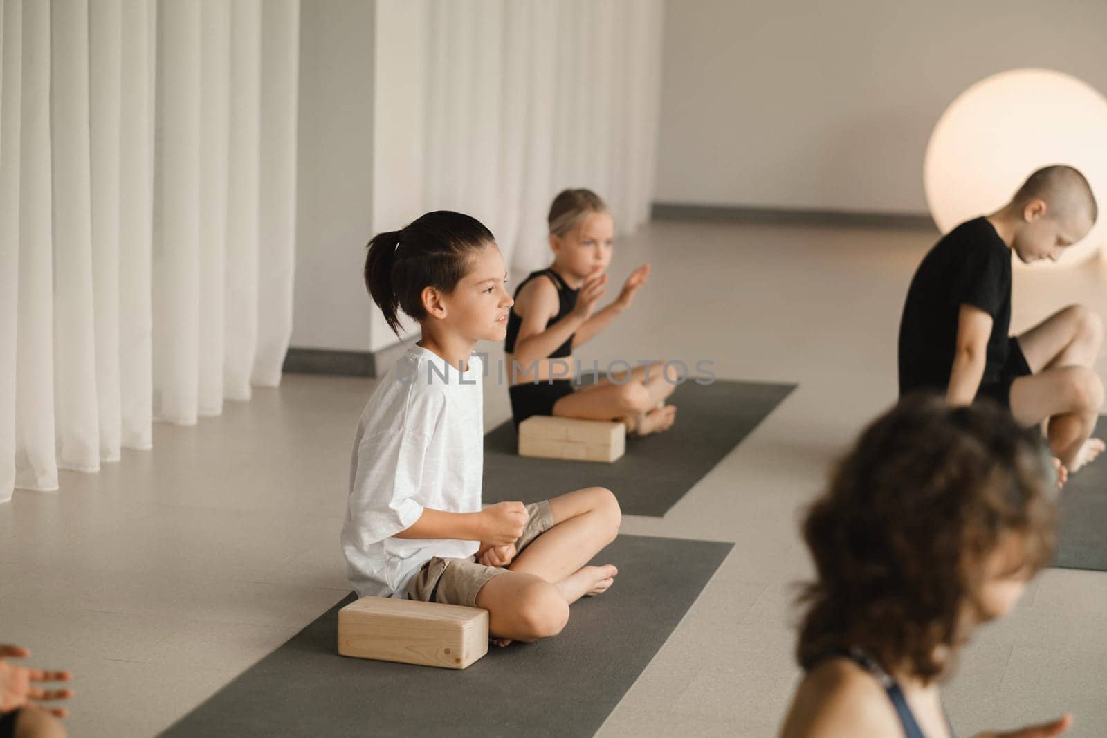 Children do yoga in the gym on support blocks. Children's gymnastics.