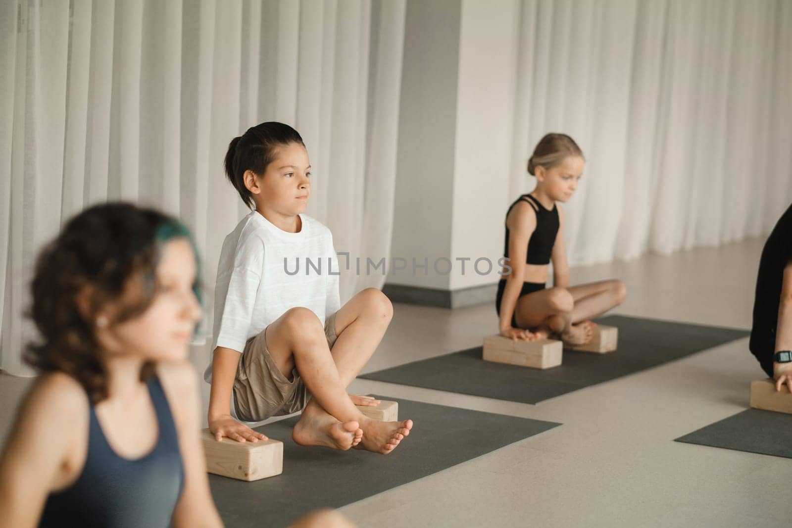 Children do yoga in the gym on support blocks. Children's gymnastics.