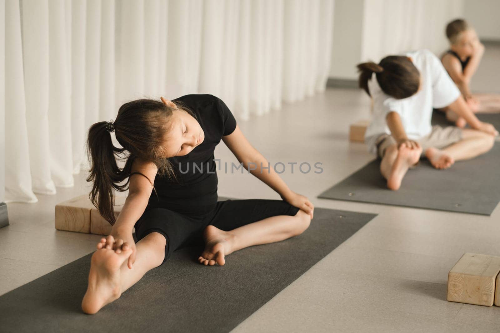 Children do Yoga in the fitness room. Children's gymnastics by Lobachad