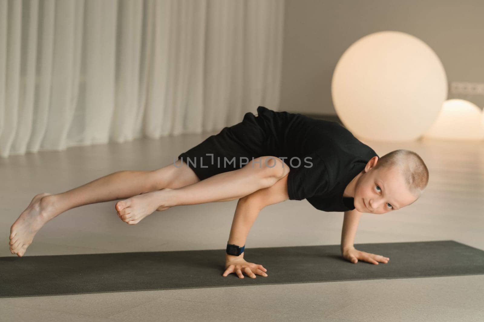 A child practices yoga poses indoors. Children's yoga.