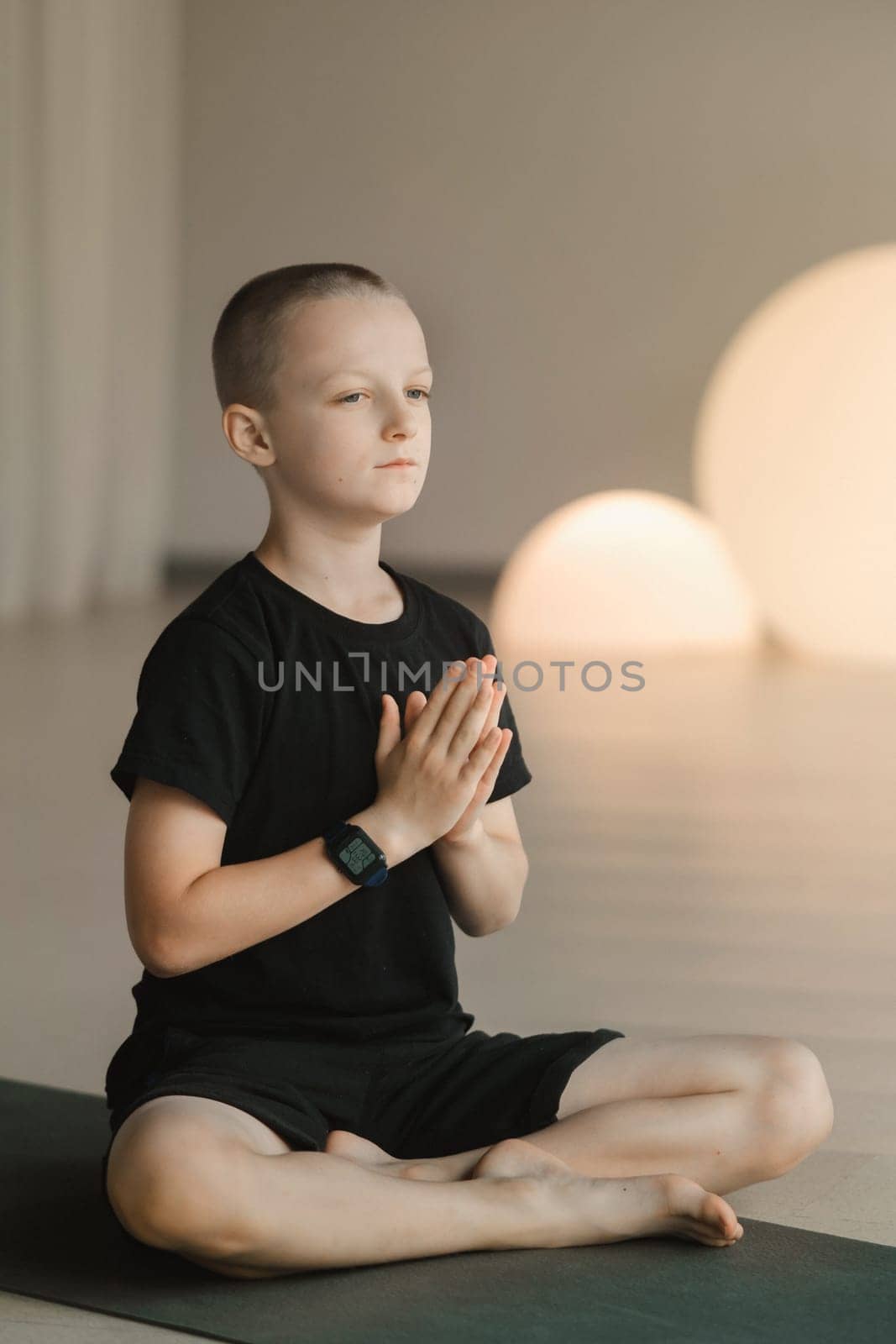 A child practices yoga poses indoors. Children's yoga by Lobachad