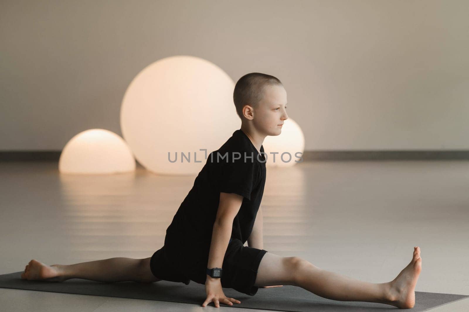 A child practices yoga poses indoors. Children's yoga.