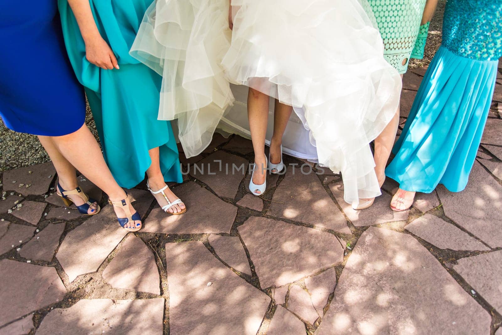 Bride and bridesmaids show off their shoes at wedding. by Satura86