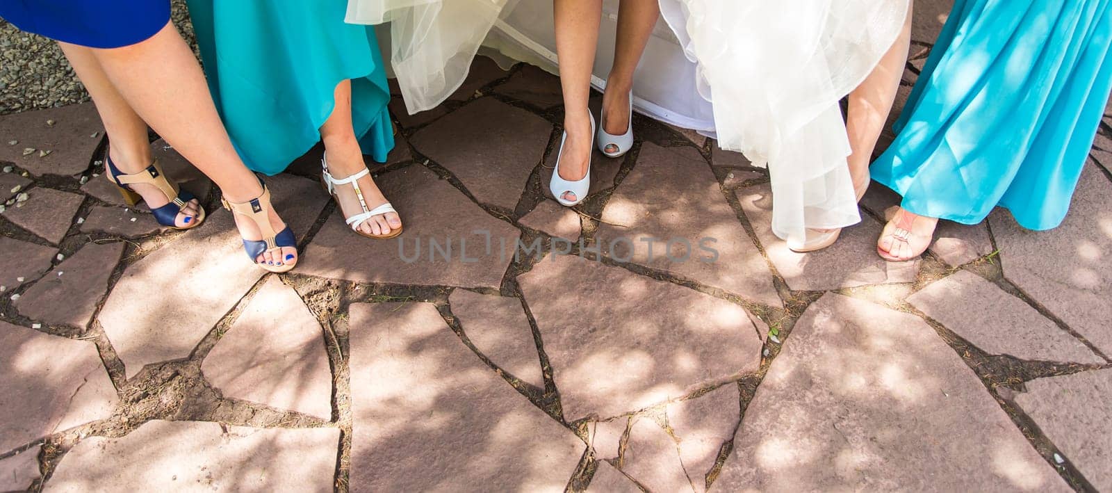 Bride and bridesmaids show off their shoes at wedding. by Satura86