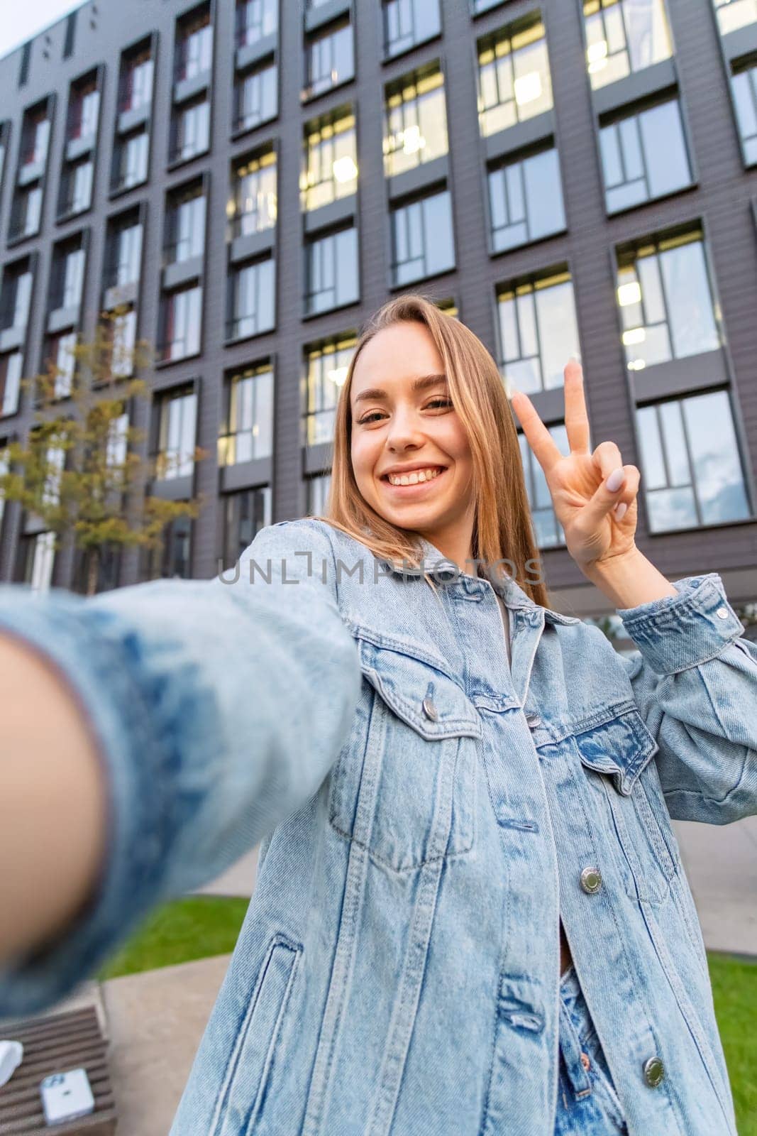 Woman in a great mood takes a selfie and shows a piece in the street.