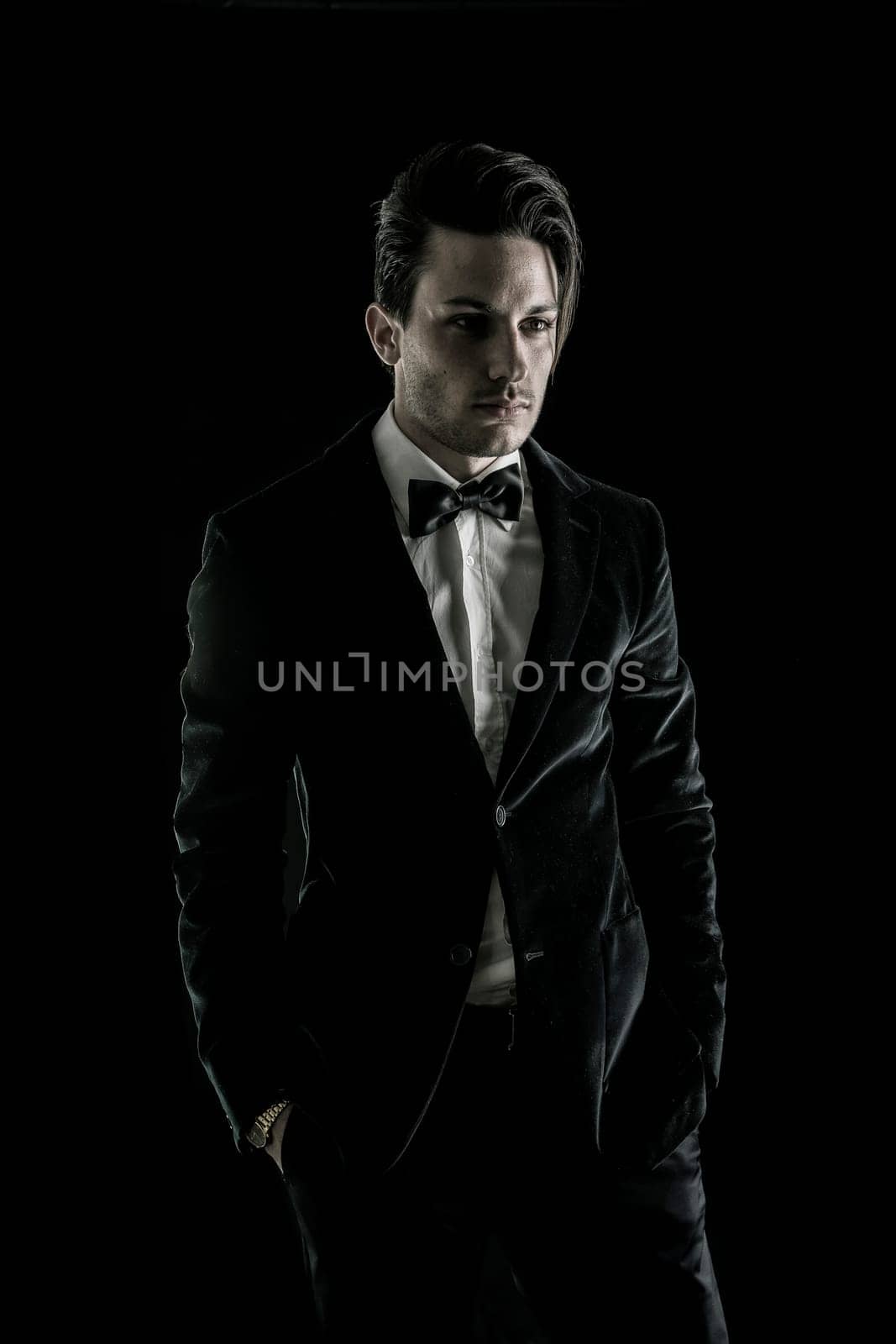 A man in a tuxedo poses for a picture