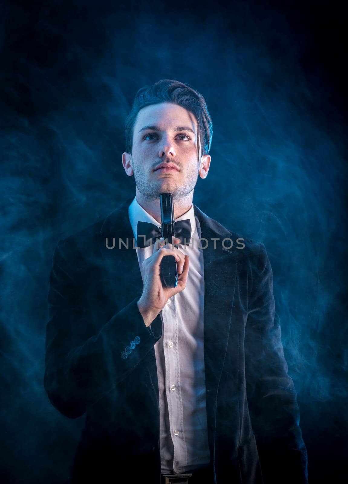 Photo of a man in a tuxedo holding a gun towards his head, threatening to commit suicide by artofphoto