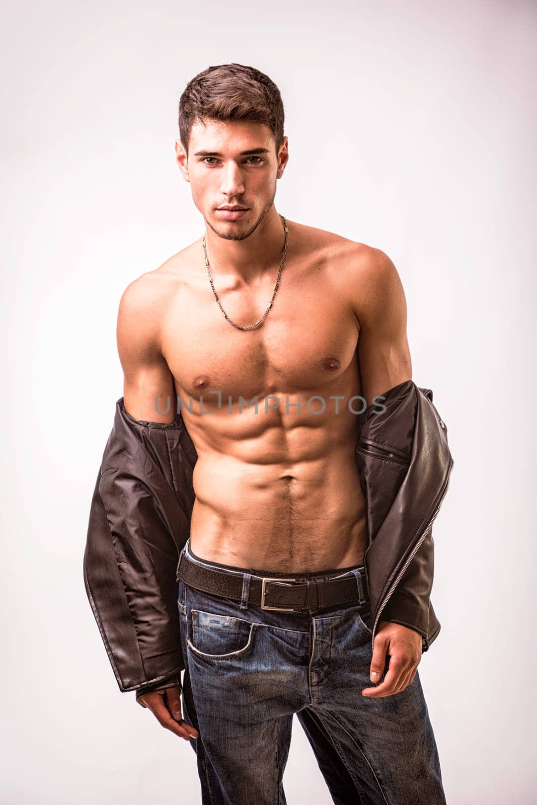 Photo of a rugged and stylish man posing in jeans and a leather jacket by artofphoto