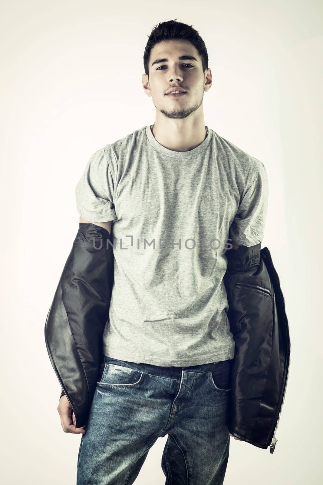 Photo of a man holding a black jacket in casual attire by artofphoto