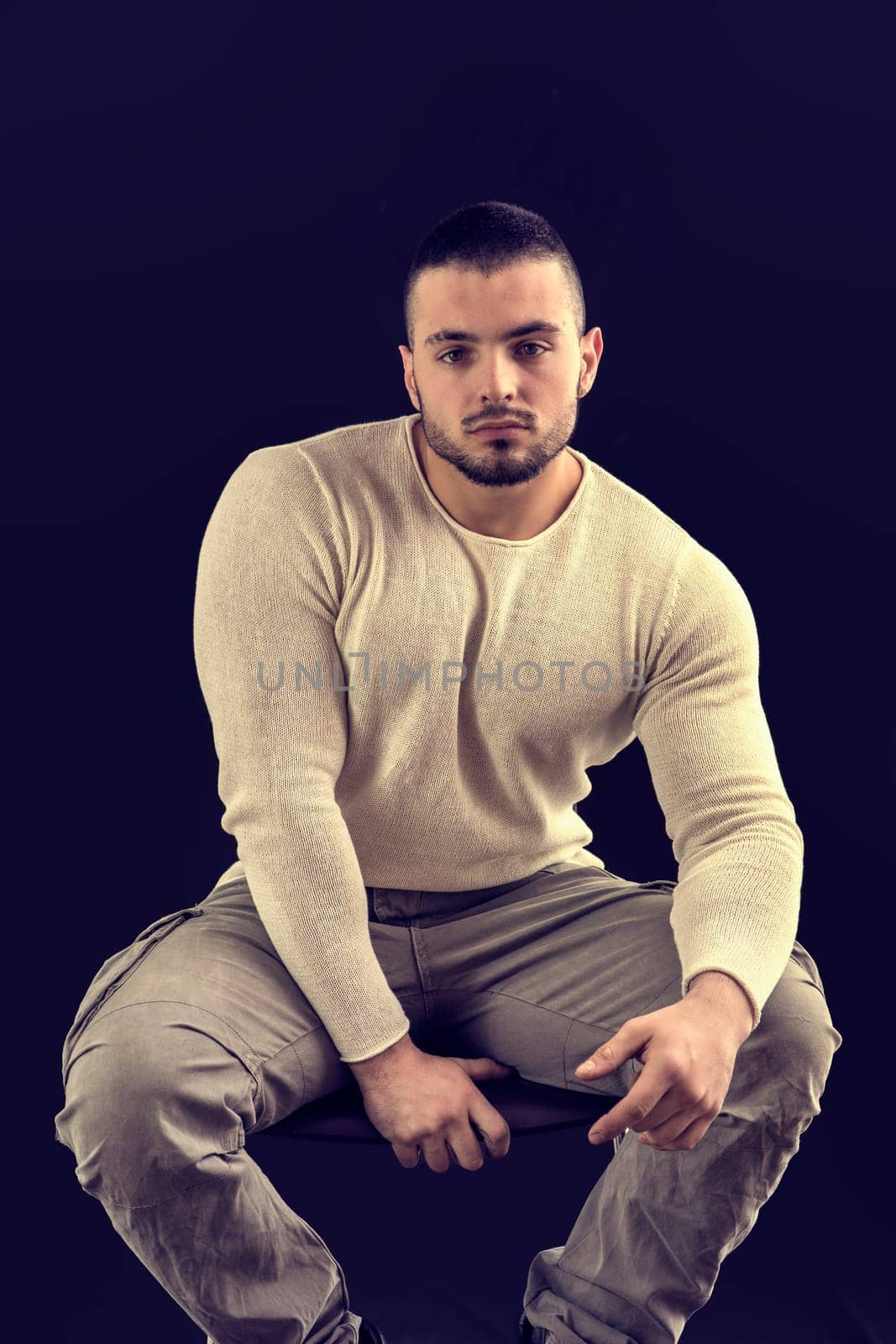 Photo of a man with a relaxed posture sitting on a stool by artofphoto