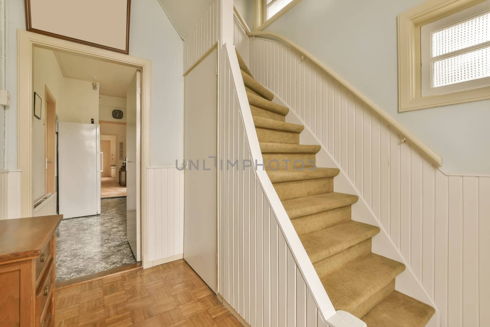 a staircase leading up to the second floor in a new home with wood floors and white panelling on the walls