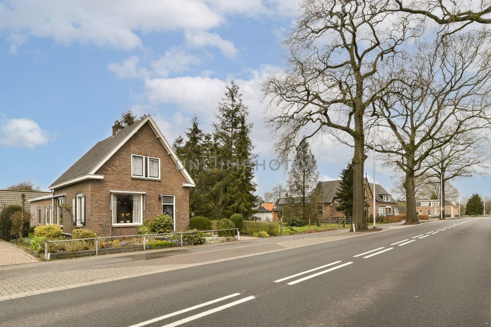 a street with houses on the side of a road by casamedia