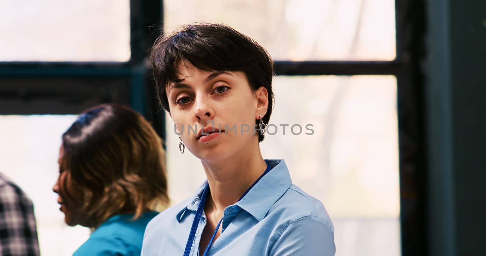 Cheerful employee arranging stylish clothes, working at modern boutique visual. Caucasian manager putting hangers with fashionable merchandise on racks in shopping centre. Fashion concept