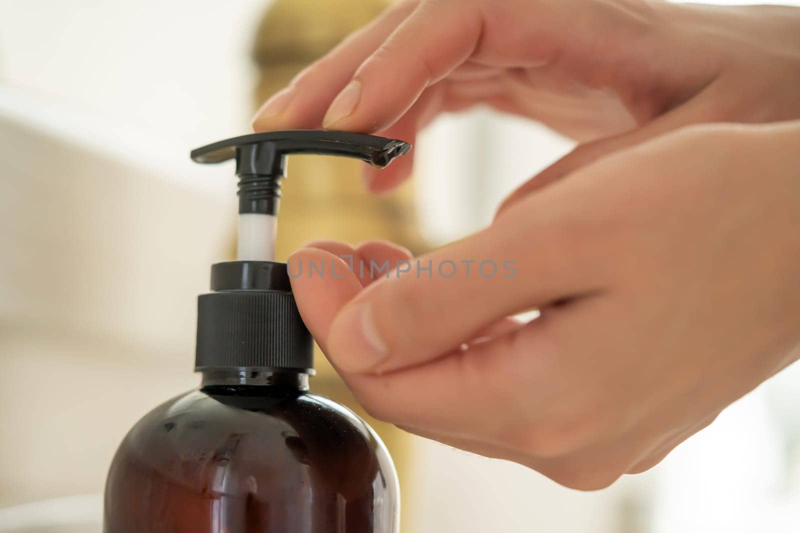 The girl washes her hands with liquid soap under water, the woman takes care of her health and cleanliness, disinfects her hands.