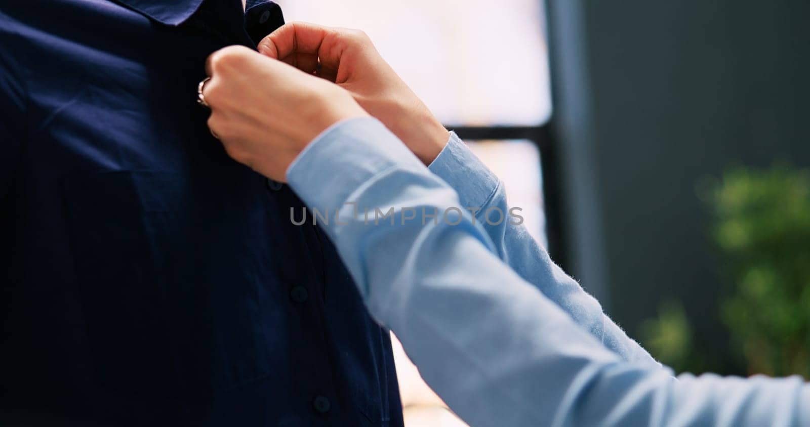 Worker arranging shirt on mannequin, checking stylish merchandise in modern boutique. Caucasian employee working at store visual, looking at hangers full with new fashion collection in shopping mall