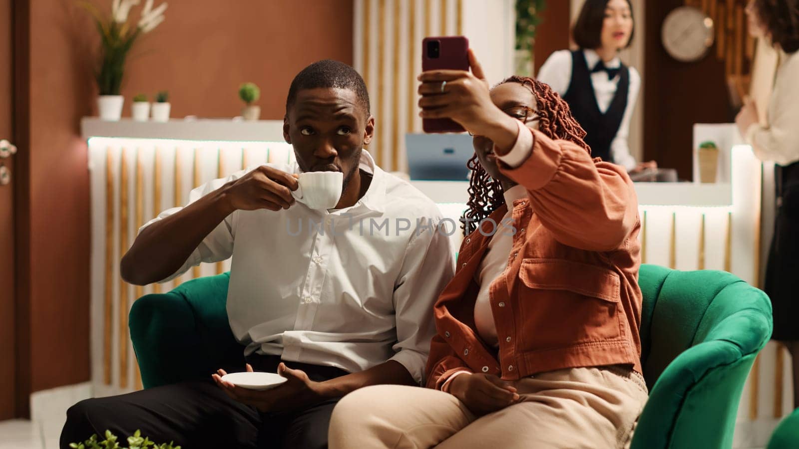 Newlyweds enjoying coffee in hotel lobby by DCStudio