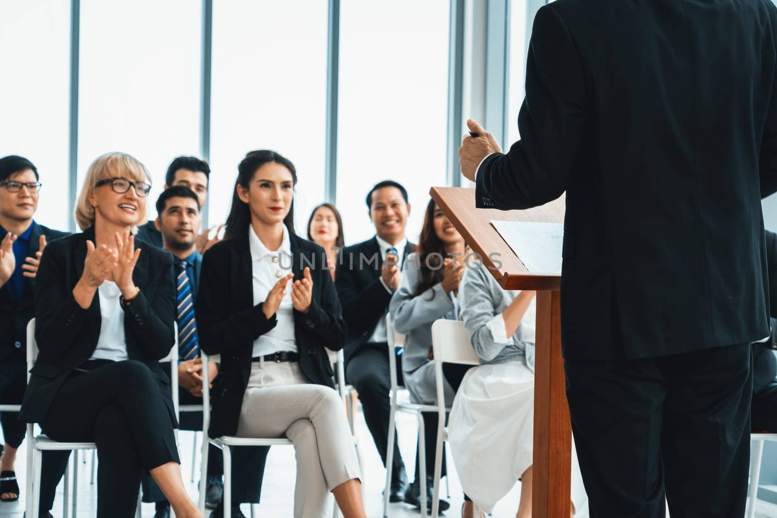 Group of business people meeting in a seminar conference . Audience listening to instructor in employee education training session . Office worker community summit forum with expert speaker . Jivy