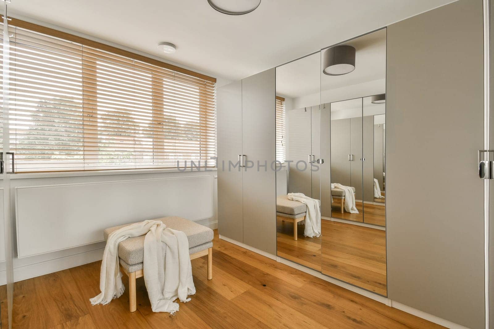 a modern bathroom with wood flooring and large mirrors on the wall, along with a white bathrobear