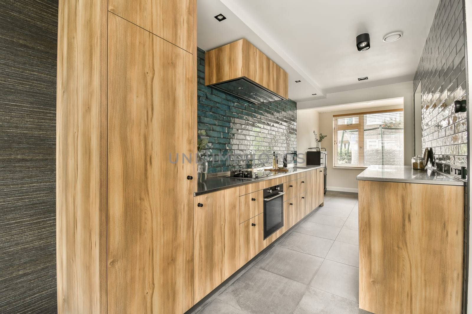 a kitchen with wood cabinets and a blue brick wall by casamedia