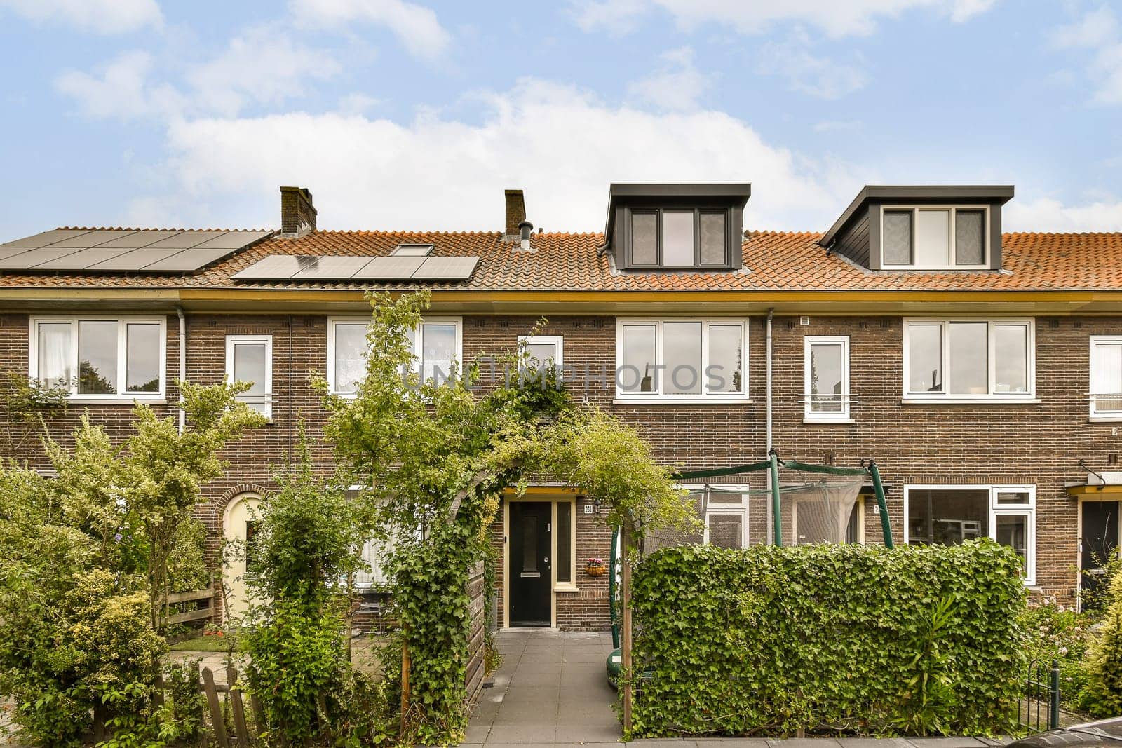 the front of a brick house with a brown roof by casamedia