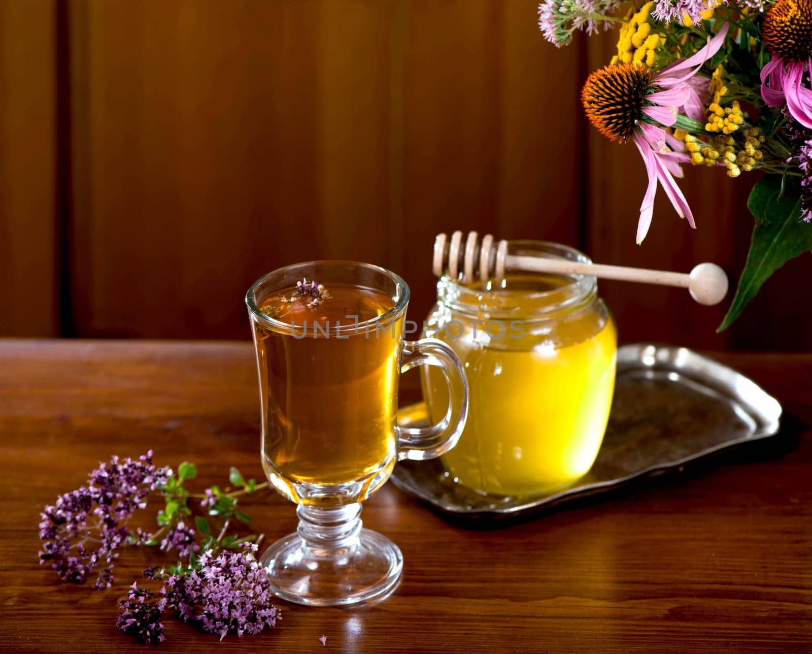 Still life from medicinal herbs, honey, herbal tea on a wooden background by aprilphoto