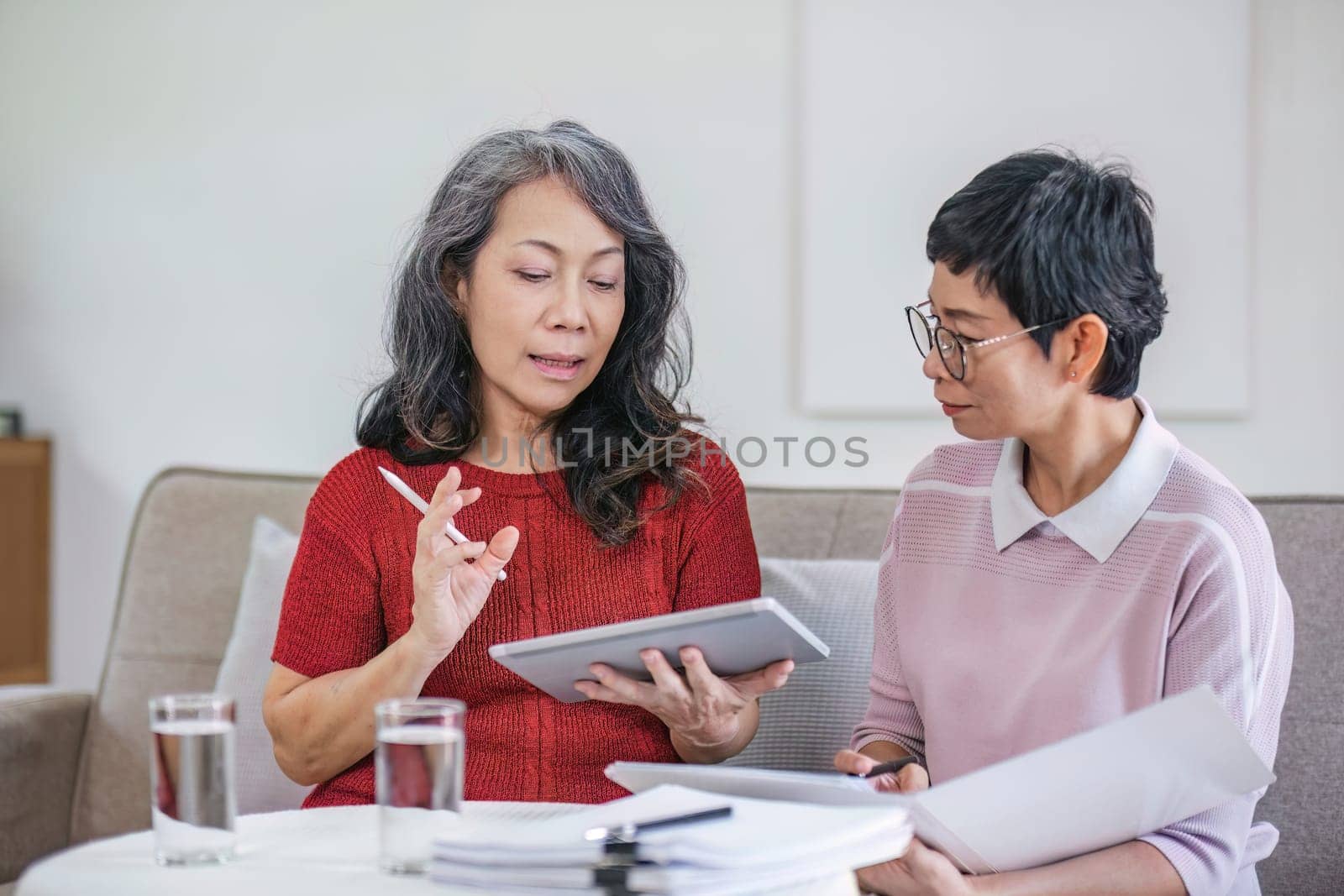 Senior woman planning future life insurance and finance happily in the living room..