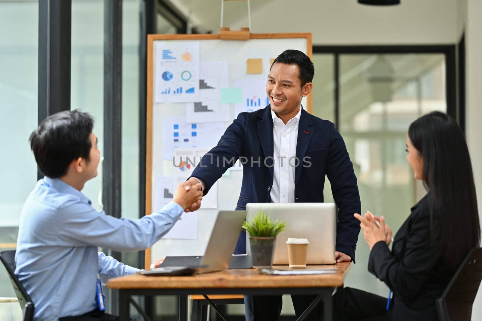 Confident male team leader shaking hands after successful meeting. Teamwork, success and support.